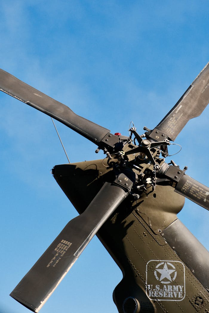 Tail rotor of a military helicopter captured from below, highlighting engineering details against a clear sky.